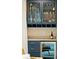 Stylish bar area with a wine cooler, wine storage, glass shelving, and attractive blue cabinetry at 155 Wingo Way # 433, Mount Pleasant, SC 29464