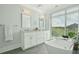 Bright bathroom featuring a soaking tub, double vanity, and large window with picturesque views at 155 Wingo Way # 433, Mount Pleasant, SC 29464