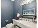 Stylish powder room with blue walls, elegant mirror, and marble countertop at 155 Wingo Way # 433, Mount Pleasant, SC 29464