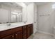 Bathroom with a double sink vanity with wood cabinets, a large mirror, and tiled floors at 169 Longford Dr, Summerville, SC 29483