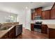 Kitchen with stainless steel appliances, granite countertops, tiled backsplash, and dark wood cabinetry at 169 Longford Dr, Summerville, SC 29483