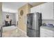 Bright kitchen with stainless steel fridge, white cabinets, and tile floors at 1954 Treebark Dr, Charleston, SC 29414