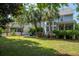 Inviting backyard with a deck, seating, and well-manicured lawn framed by mature palm trees at 1977 Pierce St, Charleston, SC 29492