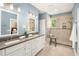 An elegant bathroom with a double vanity, a walk-in shower with a seat, and modern lighting at 1977 Pierce St, Charleston, SC 29492
