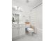 A well-lit bathroom with white fixtures, a shower with a curtain, and a tiled floor at 1977 Pierce St, Charleston, SC 29492
