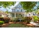 Charming two-story home featuring a welcoming front porch with white columns and beautifully landscaped yard at 1977 Pierce St, Charleston, SC 29492