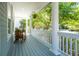 Relaxing front porch with comfortable chair, offering a serene view of the surrounding trees and neighborhood at 1977 Pierce St, Charleston, SC 29492