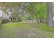 Spacious backyard featuring a privacy fence, screened-in porch, and mature trees, offering a peaceful outdoor space at 2042 Dogwood Rd, Charleston, SC 29414