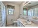 Bright bathroom featuring wallpaper, framed mirror, matching vanity and blue and green patterned shower curtain at 2042 Dogwood Rd, Charleston, SC 29414