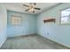 Light blue bedroom features a ceiling fan, neutral carpet, and two windows providing natural light at 2042 Dogwood Rd, Charleston, SC 29414