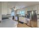 Well-lit kitchen with stainless steel refrigerator and plentiful white cabinets at 2042 Dogwood Rd, Charleston, SC 29414