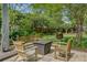 Inviting outdoor patio with lawn featuring a gas burning fire pit and ample seating at 210 S Gum St, Summerville, SC 29483