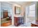 Charming bathroom with a wooden vanity, white countertop, and a view into an adjacent bedroom at 210 S Gum St, Summerville, SC 29483