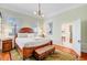 Comfortable bedroom featuring a wooden bed frame, sitting bench, and a doorway to the laundry room at 210 S Gum St, Summerville, SC 29483