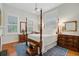 Charming bedroom with four-poster bed, hardwood floors, and natural light from shuttered windows at 210 S Gum St, Summerville, SC 29483