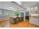 Spacious kitchen featuring a large island, bar seating, hardwood floors, and lots of natural light at 210 S Gum St, Summerville, SC 29483