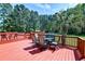 Outdoor deck with table and seating with a view of the property's swimming pool and trees at 2102 Williams Rd, Ruffin, SC 29475
