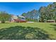 View of the backyard with a pool, deck and home surrounded by green grass and trees at 2102 Williams Rd, Ruffin, SC 29475
