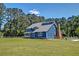 Charming two-story home with a metal roof and lush landscaping at 2102 Williams Rd, Ruffin, SC 29475