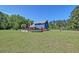 Expansive view of the property featuring a blue house, in-ground pool, and green grass at 2102 Williams Rd, Ruffin, SC 29475