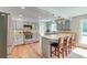 Well-lit kitchen featuring stainless steel appliances, a tiled breakfast bar, and warm wood floors at 2102 Williams Rd, Ruffin, SC 29475