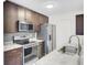 Kitchen features stainless steel appliances, dark wood cabinets, and white countertops at 2159 Spoleto Ln # E, North Charleston, SC 29406