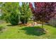 Lush backyard with grass, mature trees, and a peaceful seating area at 2290 Deer Sight Way, Mount Pleasant, SC 29466