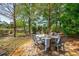 Outdoor dining area with a table set for six, shaded by mature trees and a tranquil setting at 2290 Deer Sight Way, Mount Pleasant, SC 29466