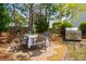 Charming backyard patio features a dining set, grill, and lush landscaping with an arched gateway and privacy fence at 2290 Deer Sight Way, Mount Pleasant, SC 29466