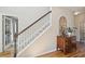 Carpeted staircase featuring hardwood floors and a stylish foyer with an antique sideboard at 2290 Deer Sight Way, Mount Pleasant, SC 29466