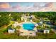 Stunning aerial view of community pool, palm trees, cabanas, and clubhouse under a partly cloudy sky at 2292 Skyler Dr, Mount Pleasant, SC 29466