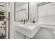 Stylish bathroom featuring a wall-mounted sink, modern faucet, and window with blind at 24 Hanover St, Charleston, SC 29403