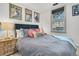 Bedroom featuring a queen bed, vintage posters, and a view from a window with woven shades at 24 Hanover St, Charleston, SC 29403