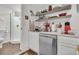 Convenient wet bar area featuring a stainless steel dishwasher and floating wood shelves at 24 Hanover St, Charleston, SC 29403