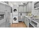 Updated kitchen features stainless steel appliances, gray cabinets and a stacked washer and dryer at 24 Hanover St, Charleston, SC 29403
