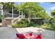 Relaxing backyard area featuring a cozy outdoor lounge, mature landscaping, and partial view of the home at 2405 Louisville St, Charleston, SC 29492