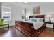 Comfortable bedroom with a wood bed, natural light, hardwood floors, and a colorful painting at 2405 Louisville St, Charleston, SC 29492