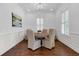 Formal dining room with a round wood table, wainscoting, plantation shutters and elegant lighting at 2405 Louisville St, Charleston, SC 29492