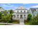 Beautiful two-story home showcasing a covered porch, white railings, and manicured landscaping at 2405 Louisville St, Charleston, SC 29492