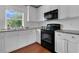 Modern kitchen with black appliances, white cabinets, and granite countertops, perfect for cooking and entertaining at 2405 Louisville St, Charleston, SC 29492