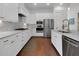 Contemporary kitchen with white cabinets, marble countertops, and stainless steel appliances, perfect for culinary enthusiasts at 2405 Louisville St, Charleston, SC 29492