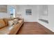Bright living room featuring hardwood floors, large windows, and a comfortable leather sofa at 2405 Louisville St, Charleston, SC 29492