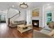 Inviting living room featuring a fireplace, hardwood floors, and staircase, providing a relaxing living space at 2405 Louisville St, Charleston, SC 29492