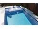 A modern pool features built-in loungers and waterfall for a serene backyard oasis at 2405 Louisville St, Charleston, SC 29492