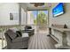 Inviting screened porch with comfortable seating, ceiling fan, and mounted TV for outdoor relaxation at 2405 Louisville St, Charleston, SC 29492