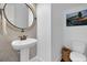 Charming powder room with a unique round mirror, pedestal sink, and modern tiling, a delightful space at 2405 Louisville St, Charleston, SC 29492