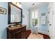 Charming bathroom with blue walls, patterned flooring, and custom vanity with a marble countertop at 2444 Darts Cove Way, Mount Pleasant, SC 29466