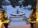 Winter scene showcasing a snow-covered front yard with fountain and festive decorations at 2444 Darts Cove Way, Mount Pleasant, SC 29466