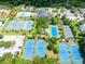 Aerial shot of multiple tennis courts surrounded by trees, amenities, and manicured landscaping at 2444 Darts Cove Way, Mount Pleasant, SC 29466