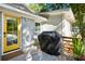 Back porch featuring outdoor kitchen, yellow door, and lush landscaping at 248 Forest Trail, Isle of Palms, SC 29451